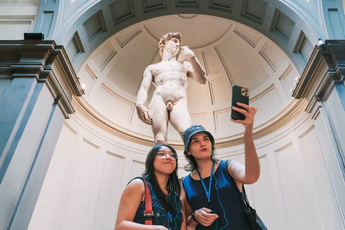 Florence: Accademia Gallery Guided Tour + Access to Michelangelo’s David Two women taking a selfie in front of the statue of david