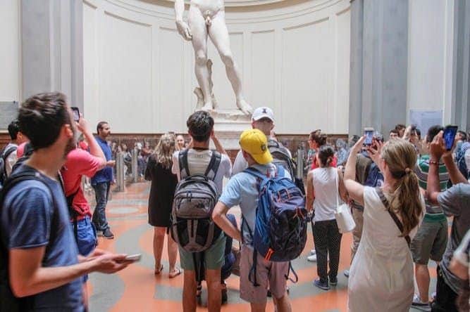 Florence: Guided Walking Tour People wander through Florence, stopping to admire its iconic statues.
