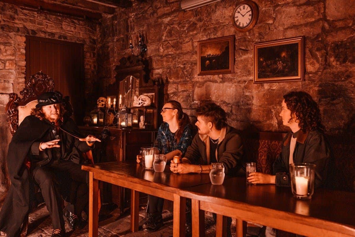 Edinburgh: Evening Ghosts & Ghouls Guided Tour + Drink Visitors enjoying a drink and a story in Meggets Celler