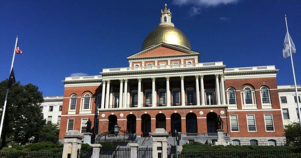 Freedom Trail: Guided Walking Tour A historic building with a golden dome, red brick walls, and white columns under a clear blue sky.