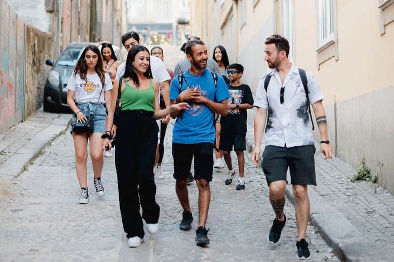 A tour guide with a wand leading a good looking group