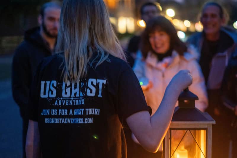 Tour guide telling ghost stories by lantern light